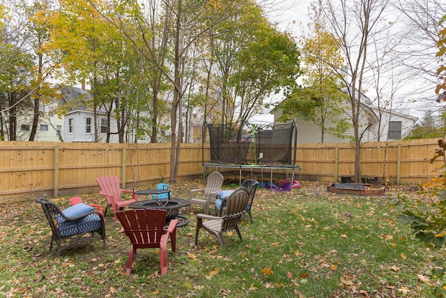 view of yard featuring an outdoor fire pit and a trampoline