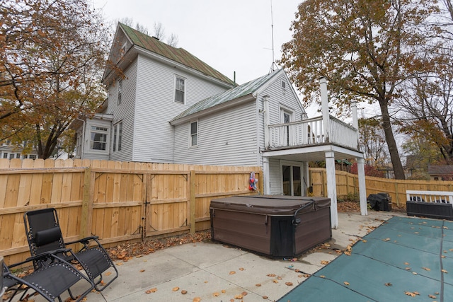 view of patio featuring a hot tub and a balcony