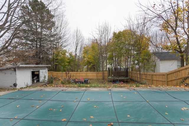 view of pool with an outdoor structure and a trampoline