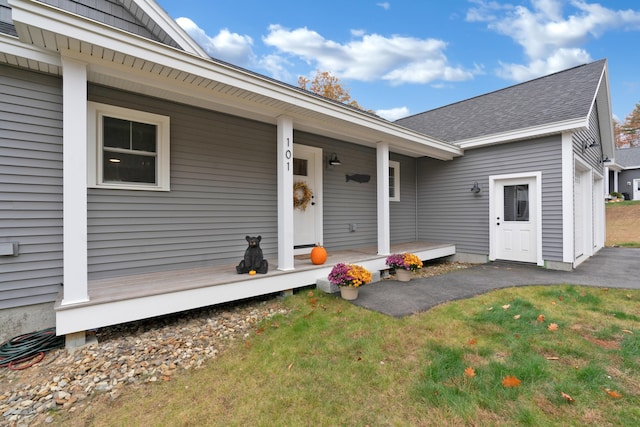 entrance to property with a yard and covered porch