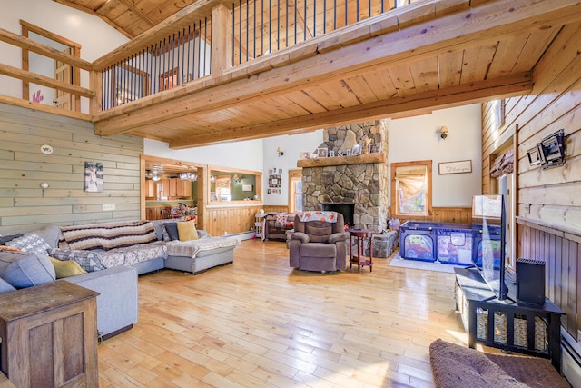 living room with light hardwood / wood-style floors, wooden walls, wooden ceiling, and a high ceiling