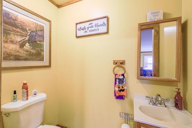 bathroom with vanity, toilet, and ornamental molding