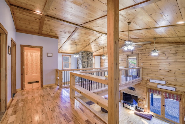 corridor featuring wood walls, lofted ceiling with beams, wooden ceiling, and light wood-type flooring