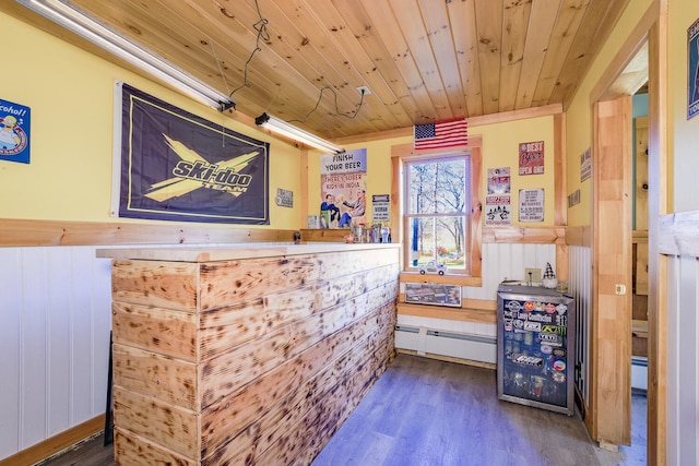 bar featuring wood ceiling, wood walls, a baseboard radiator, and dark hardwood / wood-style flooring