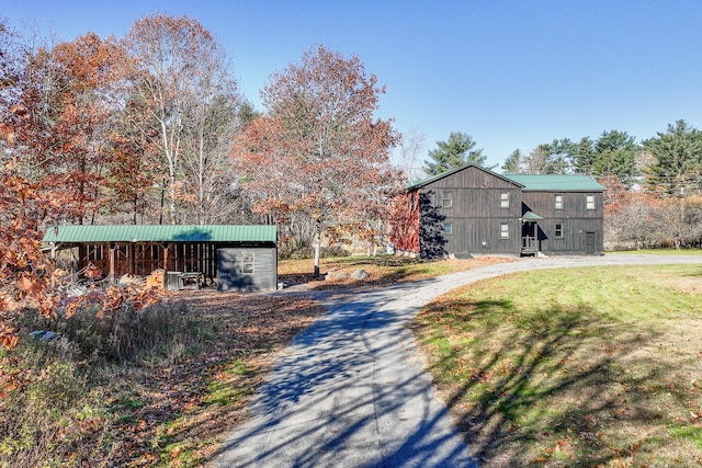 view of front of home with an outdoor structure and a front yard