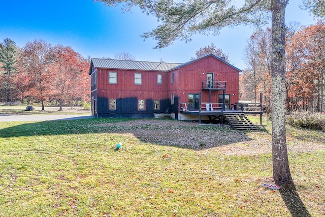 back of house featuring a wooden deck and a yard