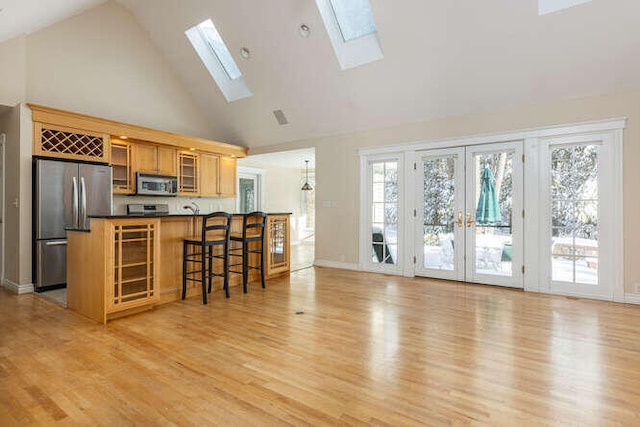 kitchen with light wood-type flooring, a healthy amount of sunlight, and appliances with stainless steel finishes