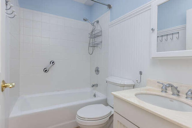 full bathroom with tiled shower / bath combo, vanity, and toilet