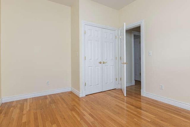 unfurnished bedroom featuring light hardwood / wood-style floors and a closet