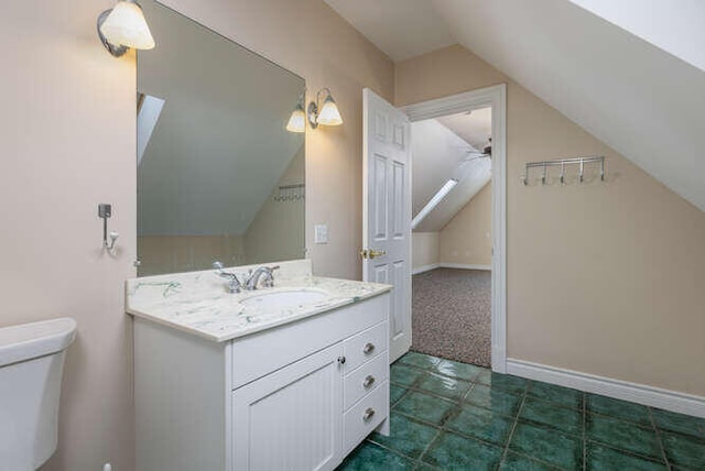 bathroom featuring vanity, vaulted ceiling, and toilet