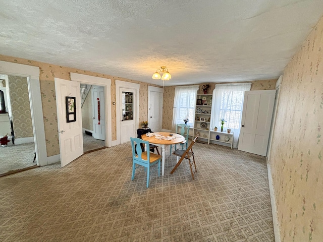 dining area with carpet and a textured ceiling