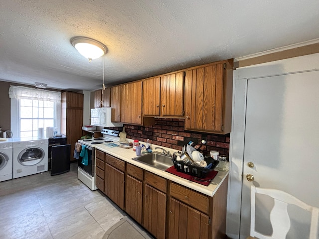 kitchen featuring tasteful backsplash, a textured ceiling, washing machine and dryer, sink, and white appliances