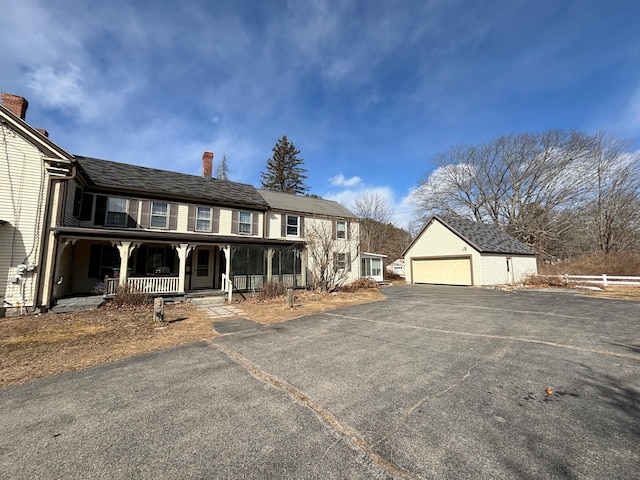 view of front of property featuring an outbuilding, a garage, and covered porch