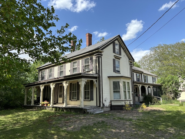 view of front of home with a sunroom, covered porch, and a front yard