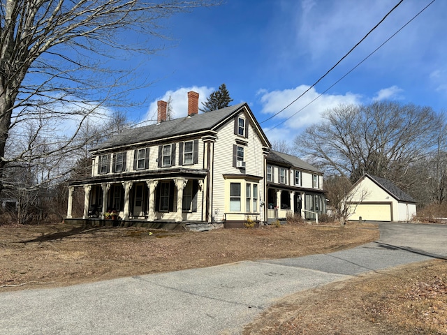 view of front of house featuring a porch, an outdoor structure, and a garage