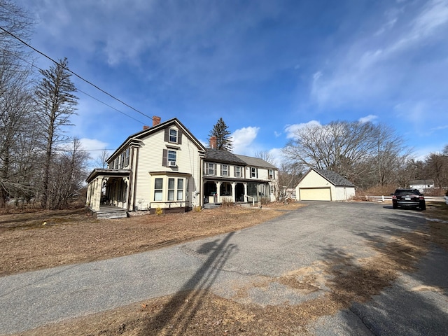 view of front of home with a porch, an outbuilding, and a garage