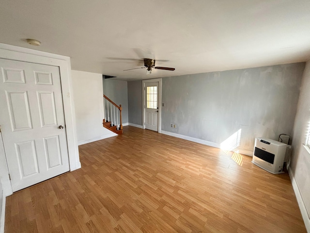 unfurnished room featuring light hardwood / wood-style floors, heating unit, and ceiling fan