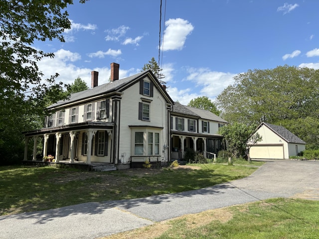 view of front of property with an outdoor structure, a garage, a front lawn, and a porch