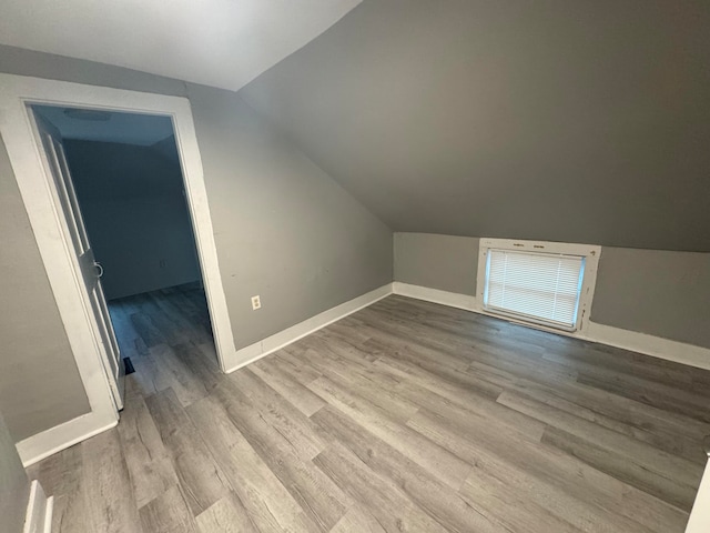 additional living space with lofted ceiling and light wood-type flooring