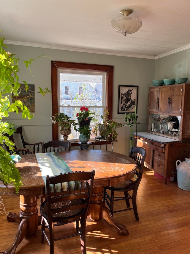 dining room featuring hardwood / wood-style floors and ornamental molding