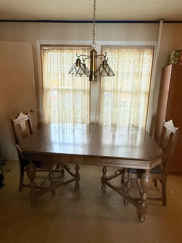 unfurnished dining area with carpet floors, a wealth of natural light, and a chandelier