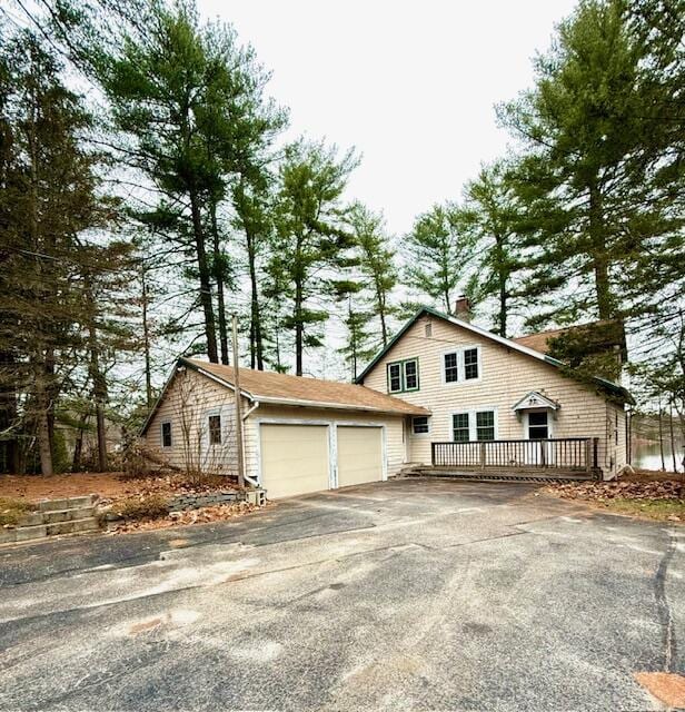 view of side of home featuring a wooden deck and a garage