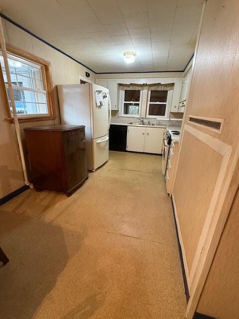 kitchen featuring white fridge, stainless steel range oven, white cabinetry, and sink