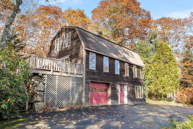 view of property exterior with a garage and a wooden deck