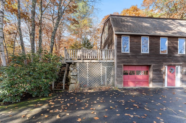 view of home's exterior featuring a garage and a wooden deck