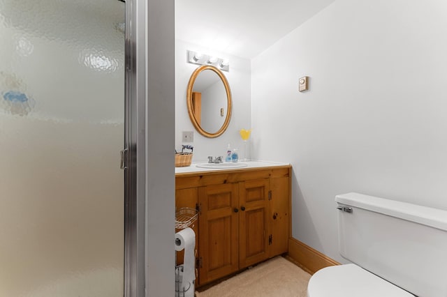 bathroom with a shower with shower door, vanity, and toilet