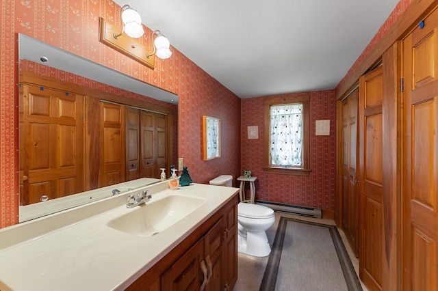 bathroom with a baseboard heating unit, vanity, and toilet