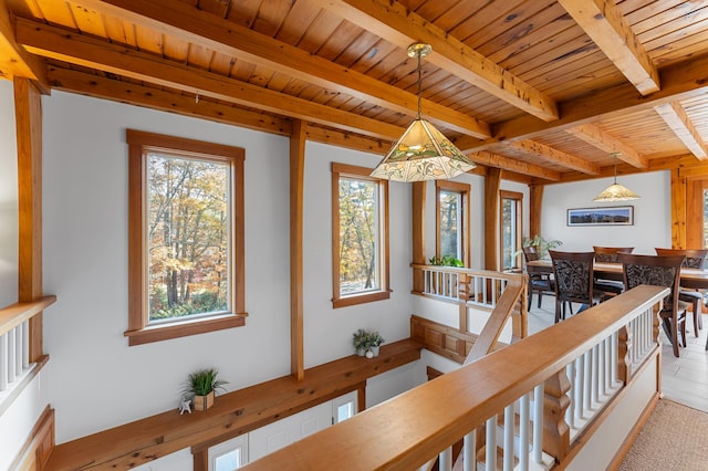 corridor featuring beamed ceiling, a wealth of natural light, and wooden ceiling