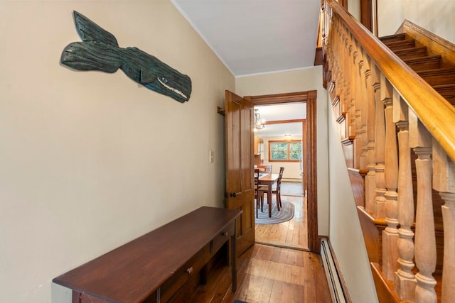 interior space with crown molding, hardwood / wood-style floors, and a baseboard radiator