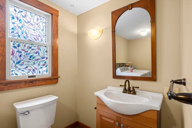 bathroom with washer / clothes dryer, vanity, and toilet