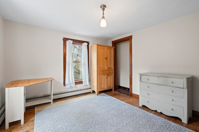 unfurnished bedroom with hardwood / wood-style flooring and a baseboard heating unit