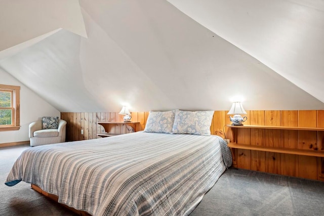 bedroom with carpet flooring, wooden walls, and vaulted ceiling