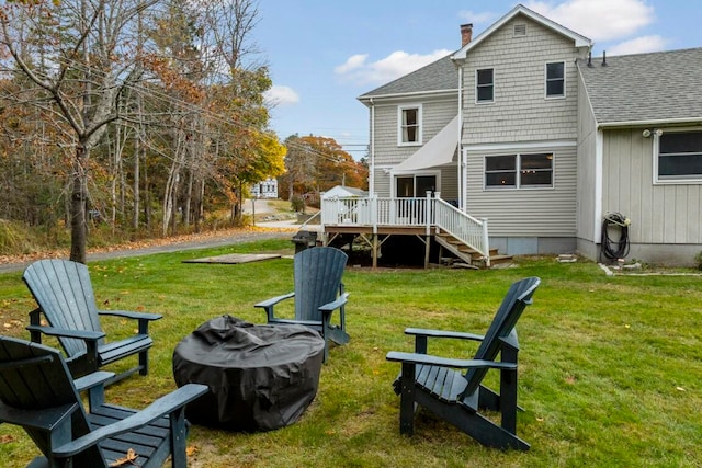 rear view of property with a wooden deck and a lawn