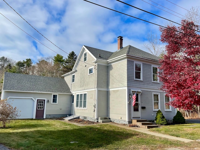 rear view of house with a yard and a garage