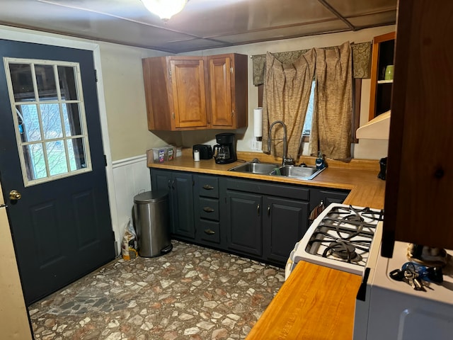 kitchen featuring wood counters, gas range gas stove, and sink