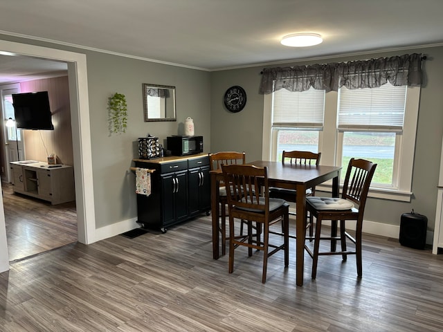 dining space with ornamental molding and hardwood / wood-style floors