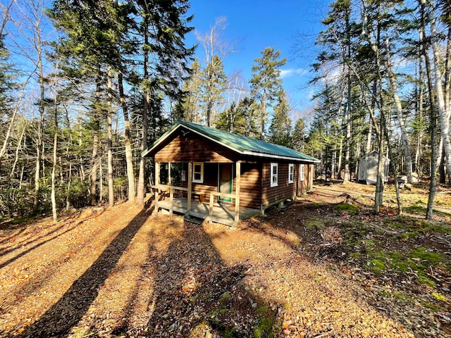 view of front of home featuring a porch and an outdoor structure