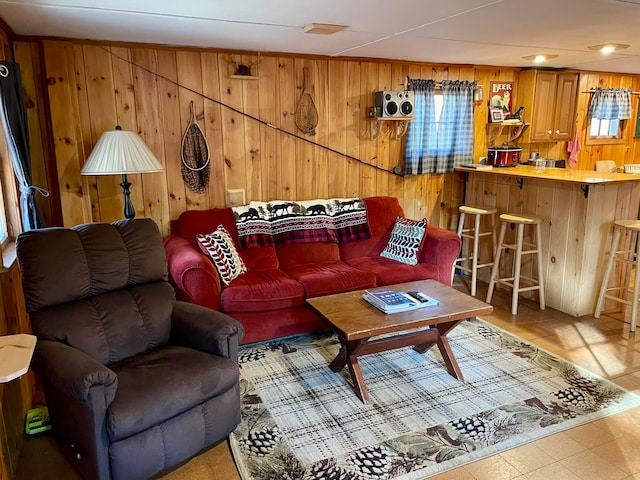 living room featuring wood walls and indoor bar