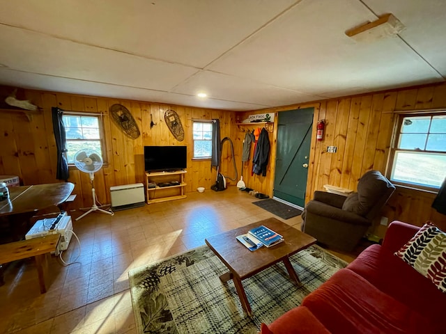 living room with a baseboard radiator and wood walls