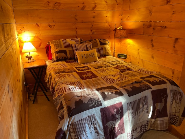 carpeted bedroom featuring wood walls