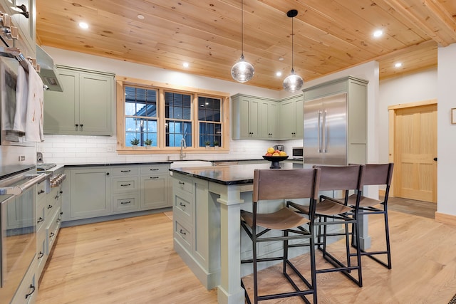 kitchen with a kitchen island, wood ceiling, stainless steel appliances, decorative light fixtures, and light hardwood / wood-style flooring