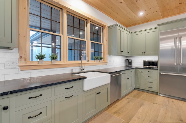 kitchen featuring wood ceiling, decorative backsplash, appliances with stainless steel finishes, light hardwood / wood-style floors, and sink