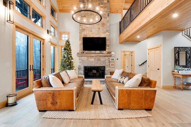 living room featuring light hardwood / wood-style flooring, a towering ceiling, and wooden ceiling