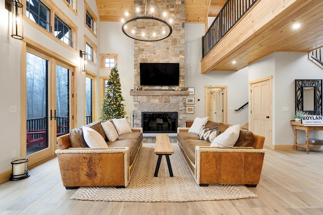 100 Morganite Way, Newry, ME 04261 - living room featuring a towering ceiling, wooden ceiling, wood finished floors, a stone fireplace, and a chandelier