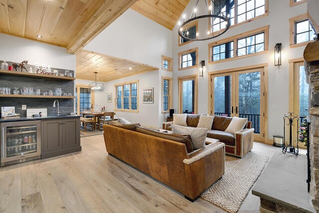 100 Morganite Way, Newry, ME 04261 - living area featuring wine cooler, wooden ceiling, high vaulted ceiling, a chandelier, and bar with sink