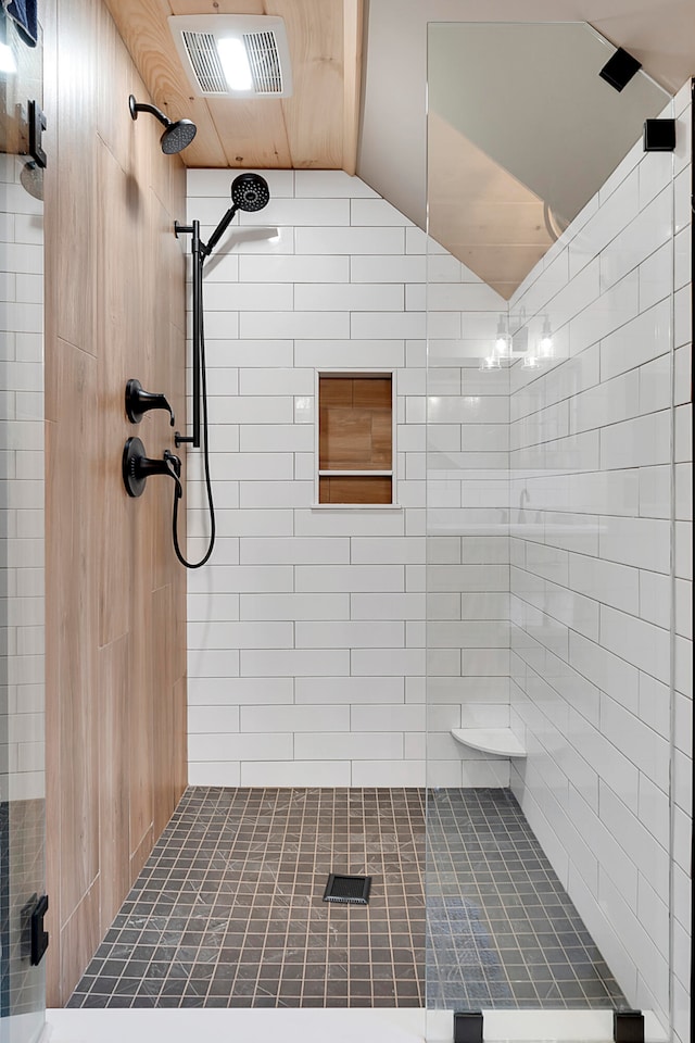 bathroom with vaulted ceiling and a tile shower